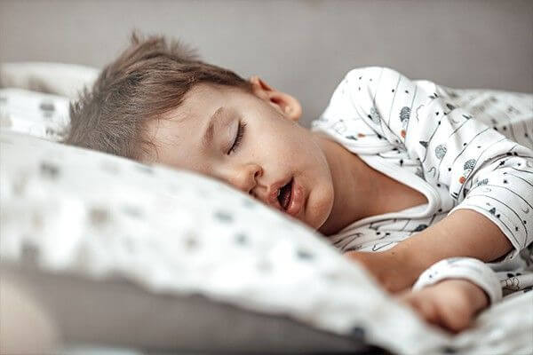 enfant dormant dans son lit, fatigué, ronfle